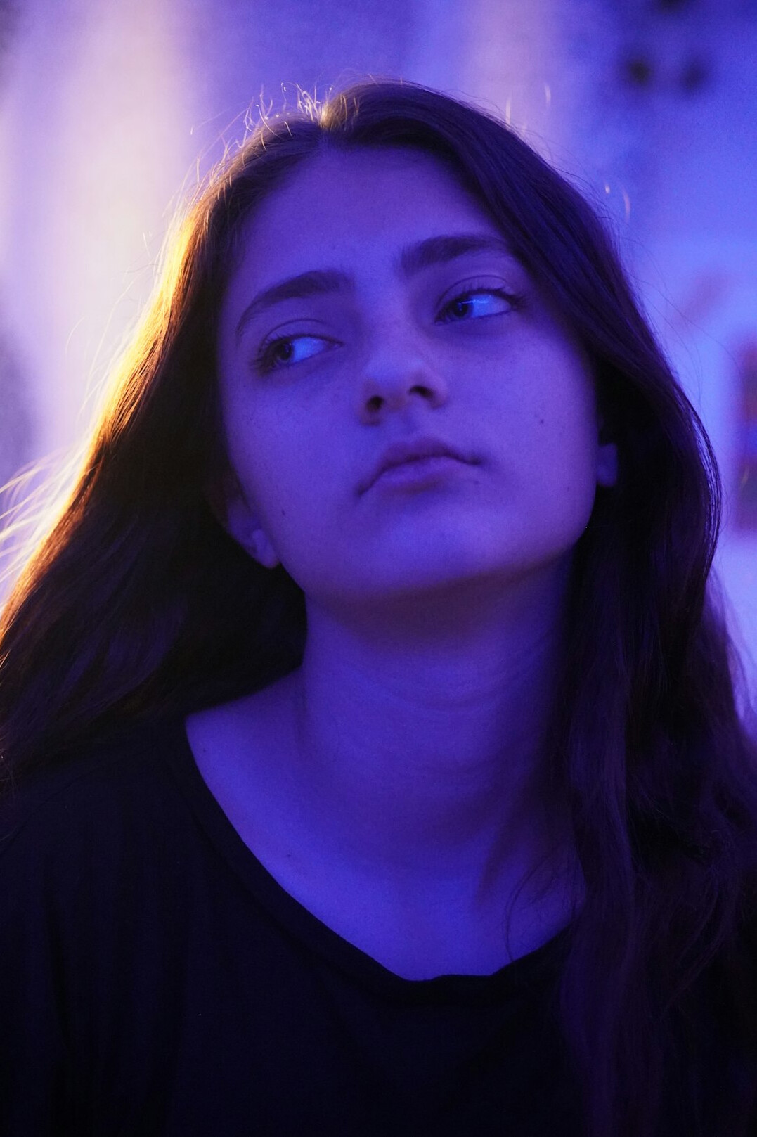 Portrait of a young woman with long hair looking at the camera
