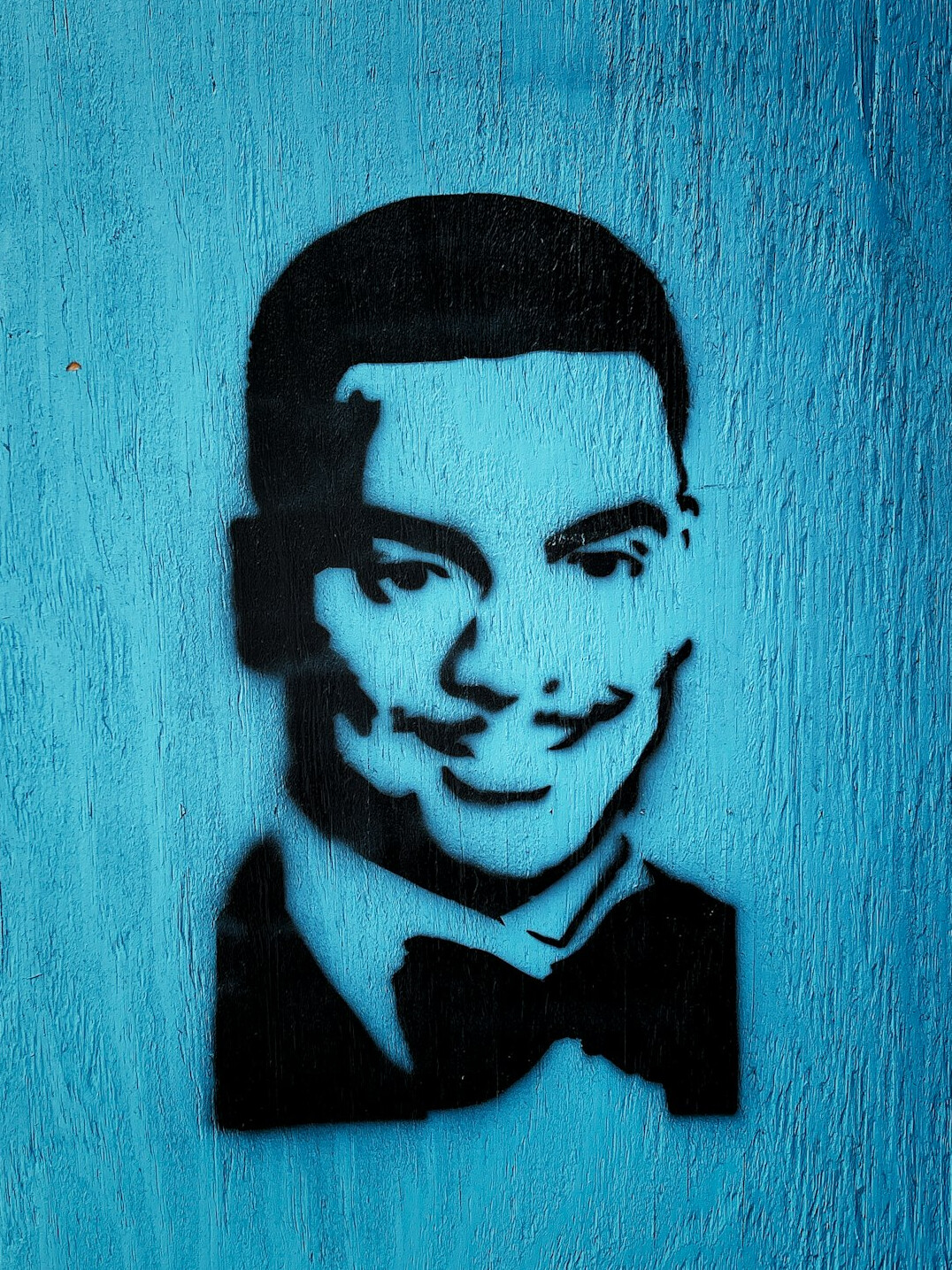 Portrait of a man with short dark hair and a light smile